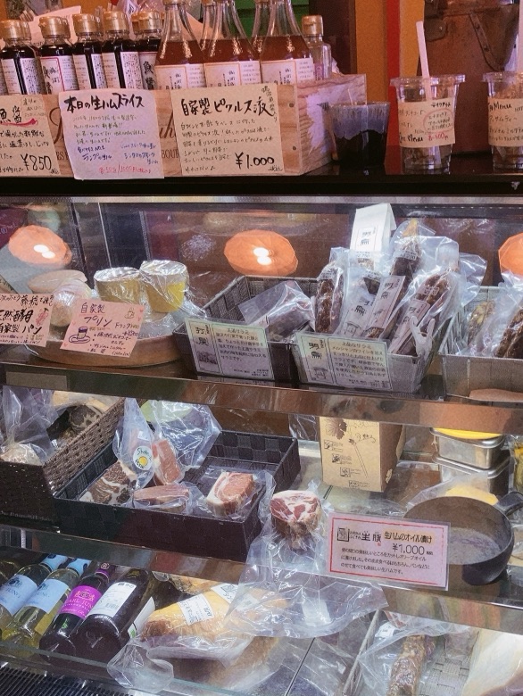 ショーケースに魚醤や生ハム、ピクルスが並んでるところ